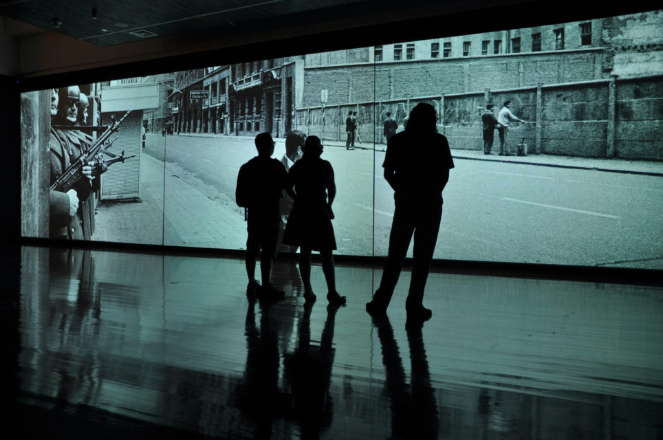 Three-screen projection showing the events around the military coup in 1973 as an audiovisual arrangement.