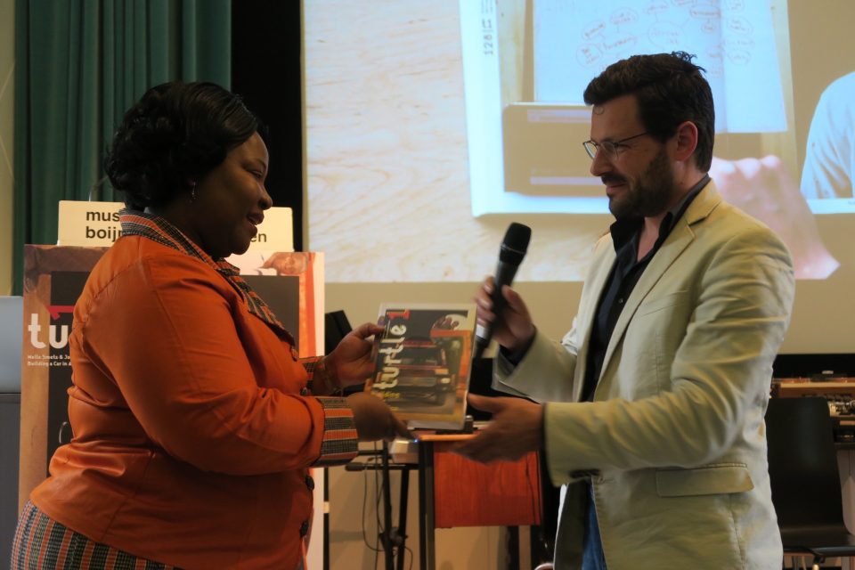 Melle hands the first copy of Turtle 1 to the Dutch ambassador of Ghana 